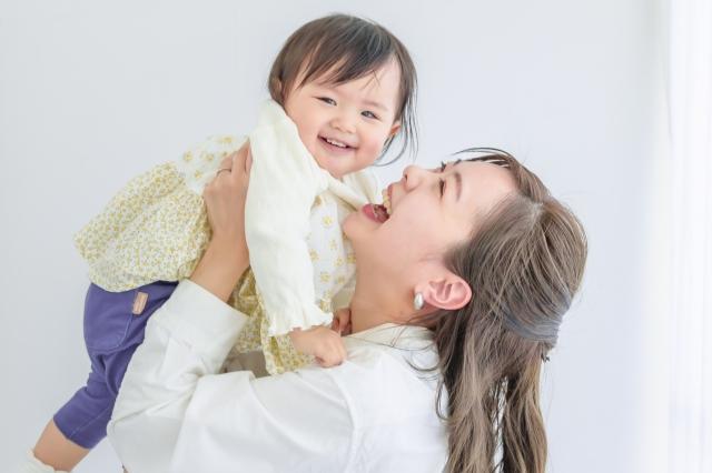 赤ちゃんを抱き上げて笑い合う母親