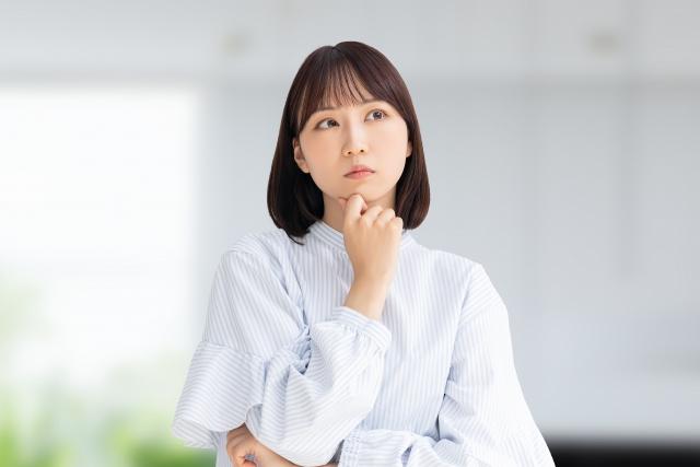 あごに手を当てて悩む女性