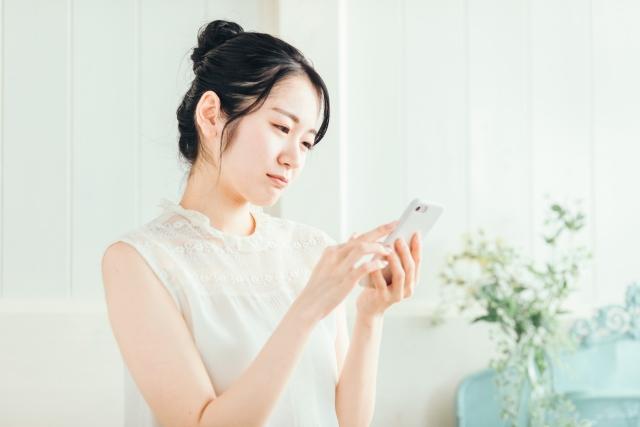 スマートフォンで調べものをする女性
